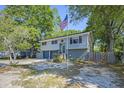 Charming two-story home with an American flag and mature trees at 14 Newark Ave, Goose Creek, SC 29445