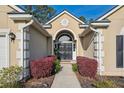 Elegant home entrance featuring a striking arched doorway and vibrant red bushes lining the walkway at 1409 Endicot Way, Mount Pleasant, SC 29466
