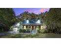 Inviting two-story home with a cozy front porch and lush landscaping at dusk at 1417 Pine Island View, Mount Pleasant, SC 29464