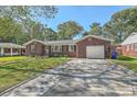 Beautiful brick home with a driveway leading to an attached garage, complemented by a neatly kept front yard at 1421 Fairfield Ave, Charleston, SC 29407