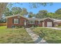 Well-maintained brick home featuring a lush front lawn and a cozy entrance with a decorative wreath on the door at 1421 Fairfield Ave, Charleston, SC 29407