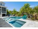 Inviting backyard pool area featuring a built-in lounge area, spa, outdoor seating, and lush landscaping for a private oasis at 1659 Pierce St, Daniel Island, SC 29492