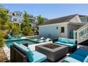 Resort style backyard with a large pool, in-pool loungers, an outdoor fire pit, ample seating, and a covered porch at 1659 Pierce St, Daniel Island, SC 29492