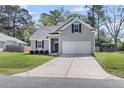 Beautiful one-story home with a gray exterior, green lawn, and a spacious driveway leading to the garage at 171 Sara St, Saint George, SC 29477