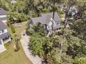 An aerial shot showcases a home with a driveway, basketball hoop, garden, and surrounding mature trees at 1828 S James Gregarie Rd, Mount Pleasant, SC 29466