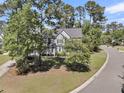 An exterior view of a home surrounded by mature trees and lush greenery, showcasing its serene setting at 1828 S James Gregarie Rd, Mount Pleasant, SC 29466