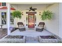 Inviting front porch with comfortable seating, hanging ferns, and decorative front door at 2021 Beckton St, North Charleston, SC 29420