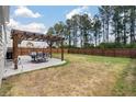 Large fenced backyard with pergola-covered patio and ample space for outdoor activities and entertaining at 210 Witch Hazel St, Summerville, SC 29486