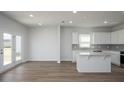 Bright, open-concept kitchen features white cabinets, modern appliances, and a central island at 211 W Bradford Pointe Dr Dr, Summerville, SC 29483