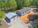 Aerial view of a single-story home and oversized garage with forest surrounding the property at 254 Nelson Farm Ln, Cross, SC 29436