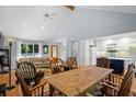 Open-concept living space with a dining area, kitchen, hardwood floors, a vaulted ceiling, and natural lighting at 2766 Old Oak Walk, Seabrook Island, SC 29455