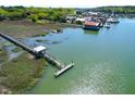 Breathtaking aerial view of the marsh and waterfront area with long pier and various boats at 29 Morrison Ave, McClellanville, SC 29458