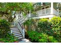 Charming two-story home with white stairs leading to a welcoming front porch and vibrant landscaping at 29 Morrison Ave, McClellanville, SC 29458