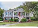Charming two story home featuring gray siding, brick accents, an inviting front porch and mature landscaping at 3567 Somerset Hills Ct, Mount Pleasant, SC 29466