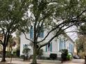 Quaint white home with blue shutters surrounded by mature trees at 41 Pitt St, Charleston, SC 29401