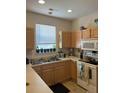 Functional kitchen featuring natural wood cabinets, laminate countertops, and ample natural light from a window at 4816 Cane Pole Ln, Summerville, SC 29485