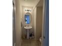 Cozy powder room with a pedestal sink, oval mirror, and tiled flooring, conveniently located for guests at 4816 Cane Pole Ln, Summerville, SC 29485