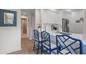 Bright kitchen features white cabinets, stainless appliances, and a breakfast bar with elegant blue chairs at 4947 Green Dolphin Way, Kiawah Island, SC 29455
