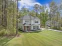 Two-story home featuring manicured lawn, inviting porch, and attached garage at 5005 Buckland Trl, Ridgeville, SC 29472
