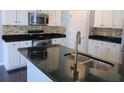 Modern kitchen features white cabinets, stainless steel appliances, granite countertops, and a stylish backsplash at 515 Flycatcher Dr, Goose Creek, SC 29445