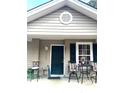 The home has a cozy front porch featuring a seating area with a table and chairs at 7943 Vermont Rd, North Charleston, SC 29418