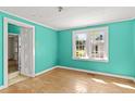Bright bedroom with turquoise walls and hardwood floors, featuring a window for natural light and ventilation at 813 W 1St North St, Summerville, SC 29483