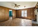 Spacious living room with vintage paneling, ceiling fan, fireplace, and natural light, providing a warm and inviting space at 813 W 1St North St, Summerville, SC 29483