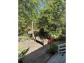 Backyard wooden deck area with pond and bench seating surrounded by a lush green, serene landscape at 815 W Carolina Rd, McClellanville, SC 29458