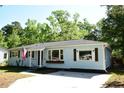 Charming single-story home featuring light blue siding, a dark roof, an American flag, and a well-maintained front yard at 816 Savage Rd, Charleston, SC 29414