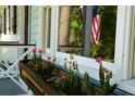 A close-up of charming exterior window box and patriotic American flag reflected in window at 816 Savage Rd, Charleston, SC 29414