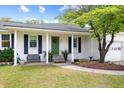 Inviting home exterior featuring a white brick facade, green door, and well-manicured lawn at 847 Condon Dr, James Island, SC 29412