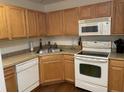 Well-maintained kitchen featuring white appliances and oak cabinets at 8634 Grassy Oak Trl, North Charleston, SC 29420