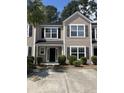 Inviting townhome exterior featuring a classic design with black shutters and a well-manicured lawn at 9032 Maple Grove Dr, Summerville, SC 29485