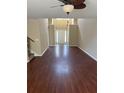 Bright open-concept room with hardwood floors, featuring stairs, white front door, and a ceiling fan at 9032 Maple Grove Dr, Summerville, SC 29485