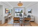 Bright living room with a water view, stylish furnishings, shiplap walls, and a woven pendant light at 14 Lockwood Dr # 2D, Charleston, SC 29401