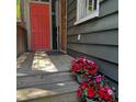 Charming wooden deck leads to a striking coral door, enhanced by vibrant flower arrangements at 152 Coming St St, Charleston, SC 29403