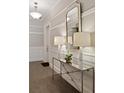 Elegant hallway features stylish console table with lamps and mirror, complemented by wainscoting and tile floors at 155 Wingo Way # 415, Mount Pleasant, SC 29464