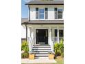 Close-up of a beautiful white brick home with a stately black front door and porch at 193 Corn Planters St, Charleston, SC 29492