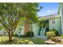 Inviting condo with light-green siding, white-trimmed windows, and well-manicured shrubs creating an appealing facade at 2010 Coldspring Dr # 502, North Charleston, SC 29406