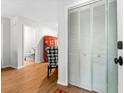 Bright hallway with wood floors, a sliding closet, and a view into a pristine bathroom and tastefully decorated room at 2010 Coldspring Dr # 502, North Charleston, SC 29406