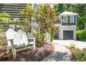 View of home with a garage and a white Adirondack chair on a stone path in the landscaped yard at 22 Frogmore Rd, Mount Pleasant, SC 29464