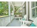 Inviting porch with a swing and white rocking chairs creating a cozy outdoor living space at 22 Frogmore Rd, Mount Pleasant, SC 29464