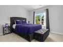 A modern bedroom displays a luxurious black bed frame, complementary bedding, and natural light at 259 Pine Shadow Dr, Goose Creek, SC 29445