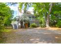Charming home featuring a covered porch and landscaped yard with a mature tree and a gravel driveway at 281 Hawthorne St, Mount Pleasant, SC 29464