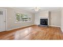 Bright living room boasts hardwood floors, a cozy fireplace, and large window offering natural light at 298 Summerset Ln, Summerville, SC 29483