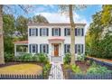 Charming two-story home with white siding, black shutters, a red roof and landscaped front yard at 305 N Civitas St, Mount Pleasant, SC 29464
