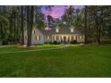 Charming white home with shuttered windows at twilight features a curved walkway leading to the front entrance at 309 Huntington Rd, Summerville, SC 29483