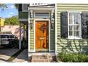 Inviting entryway with a wooden door, decorative sidelights, and brick steps at 34 Pinckney St, Charleston, SC 29401