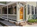 Beautiful front door with sidelights, lanterns, white trim and brick walkway at 34 Pinckney St, Charleston, SC 29401