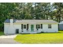 Charming one-story home featuring a white brick exterior, manicured lawn, and a quaint front porch at 407 Tammie Ave, Goose Creek, SC 29445